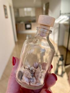 a person holding a glass bottle filled with rocks at Spacious Apartment in Vabriga