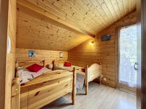 a log cabin bedroom with two beds in it at Chalet Les Hotelieres - 8 pers - Proche des pistes in Les Gets