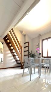 una sala da pranzo con tavolo, sedie e scala di Int 18 - Suite Lorenzo by Residence San Luca a Bologna Altre 11 foto