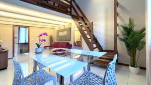 una sala da pranzo con un tavolo di vetro e sedie blu di Int 18 - Suite Lorenzo by Residence San Luca a Bologna