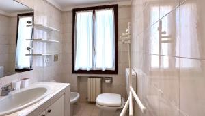 un bagno bianco con lavandino e WC di Int 18 - Suite Lorenzo by Residence San Luca a Bologna