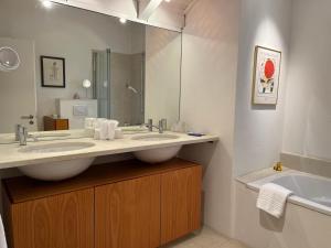 a bathroom with two sinks and a large mirror at Wine Tours Lodge in Maienfeld