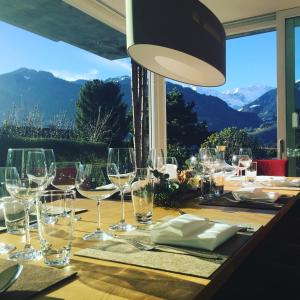 - une table avec des verres à vin et une vue dans l'établissement Wine Tours Lodge, à Maienfeld