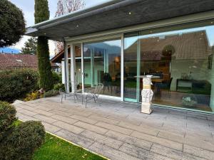 a house with glass windows and a statue on a patio at Casa Casparis in Maienfeld +7 photos