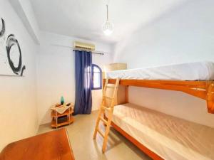 ein Schlafzimmer mit einem Etagenbett und einer Leiter in der Unterkunft Galini in Paránimfoi