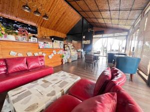 ein Wohnzimmer mit einem roten Sofa und Stühlen in der Unterkunft Nalai View Cafe'&Restaurant/Homestay in Ban Lai Nan