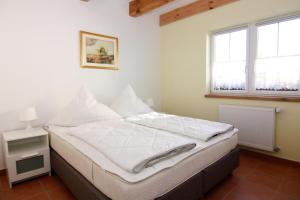 Schlafzimmer mit einem Bett mit weißer Bettwäsche und einem Fenster in der Unterkunft Farmstay Neuendorfkrug L tow in Lütow