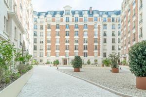 un patio vacío frente a un gran edificio en Lavie Maison Grandeur Apartment, en Neuilly-sur-Seine