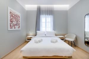 希俄斯的住宿－Giustiniani Apartments，卧室配有白色的床和2条毛巾
