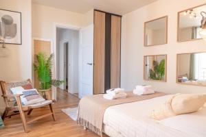 1 dormitorio con 2 camas, silla y espejo en Lavie Maison Grandeur Apartment, en Neuilly-sur-Seine