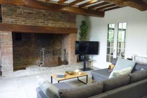 ein Wohnzimmer mit einem Sofa und einem Kamin in der Unterkunft Semi detached house Rieux in Rieux