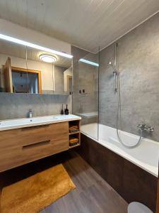 ein Bad mit einer Badewanne, einem Waschbecken und einer Dusche in der Unterkunft Chalet 1480 in Gaschurn