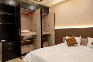 1 dormitorio con 1 cama y armario grande en Elegance Retreat, en Yelahanka