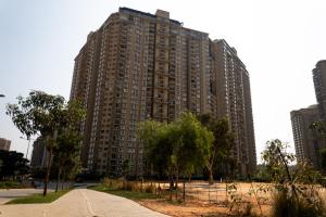 a large tall building with trees in front of it at Elegance Retreat in Yelahanka