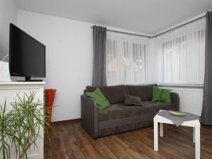 ein Wohnzimmer mit einem Sofa und einem Flachbild-TV in der Unterkunft Holiday home Luebben in Lübben