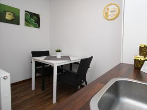 una pequeña cocina con mesa y sillas junto a una bañera en Holiday home Luebben, en Lübben