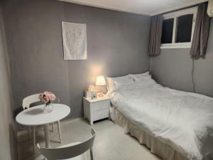 ein kleines Schlafzimmer mit einem Bett und einem Tisch in der Unterkunft Stay Mido in Busan