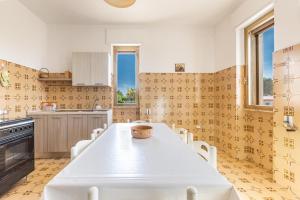 a kitchen with a white table and chairs at Salentoandmore - Villetta Anna in Marina di Pescoluse +20 photos