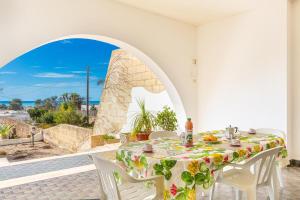 a table and chairs with a table and a view of the ocean at Salentoandmore - Villetta Anna in Marina di Pescoluse