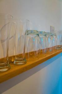 a row of wine glasses sitting on a wooden shelf at Perfect Stays in Mutely for Couples in Plymouth