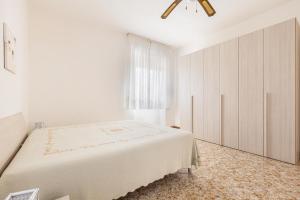a white bedroom with a bed and a window at Salentoandmore - Villetta Anna in Marina di Pescoluse