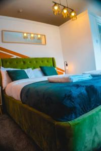 a bedroom with a large bed with a green headboard at Perfect Stays in Mutely for Couples in Plymouth