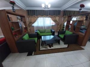 ein Wohnzimmer mit grünen Stühlen und einem Tisch in der Unterkunft Hotel romantico 