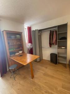 Zimmer mit einem Holztisch und einem Schrank in der Unterkunft Studio en plein centre des Vans in Les Vans