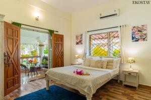 a bedroom with a bed and a large window at EKOSTAY Gold - CASA PORTO Villa in Anjuna