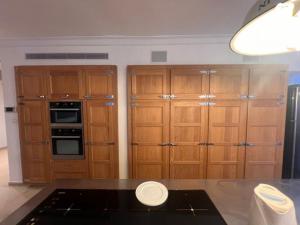 a kitchen with wooden cabinets and a counter top at אחוזת פרישמן in Herzliya B