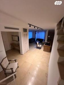 ein Wohnzimmer mit einem Sofa und einem Stuhl in der Unterkunft אחוזת פרישמן in Herzliya B