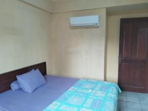 a bedroom with a bed with a blue comforter and a door at Hotel Lippo Carita bay Wanda01 in Carita