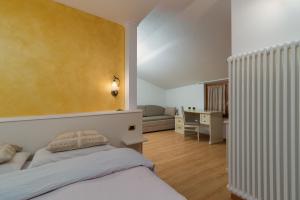 a bedroom with a bed and a living room at Hotel Opinione Dimora Storica in San Lorenzo in Banale
