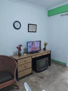 a living room with a television and a desk with a tv at Hotel Lippo Carita bay Wanda01 in Carita