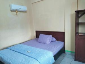 a small bedroom with a bed with a blue blanket at Hotel Lippo Carita bay Wanda01 in Carita