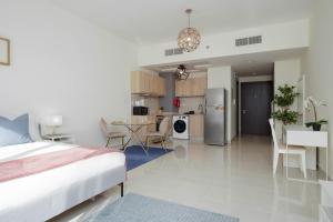 a bedroom and living room with a bed and a kitchen at Lux BnB I AG Tower I Canal Views in Dubai