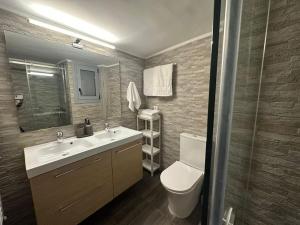 Un baño con lavabo, inodoro y espejo. en Spacious stulish 2 bd flat, en Atenas 29 fotos más
