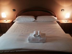 a bed with two towels on it with two lamps at Residence Cà Mazzini in San Giorgio Di Mantova