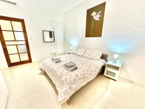 a bedroom with a bed and a table and a window at St Julians - Balluta Bay large 3 bedroom apartment in Sliema