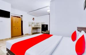 a bedroom with a red and white bed and a desk at Roomshala 159 The Hauz khas inn in New Delhi