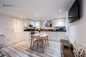 a kitchen with a white table and a table and chairs at Wheretostay 1 bed apartment Aberdeen in Aberdeen