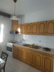 a kitchen with wooden cabinets and a sink at AGAPI'S HOUSE in Sidhirókastron