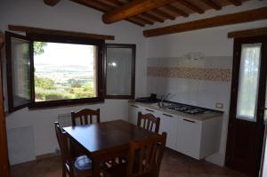 cocina con mesa, fregadero y ventana en agriturismo contrada del raglio en Potenza Picena