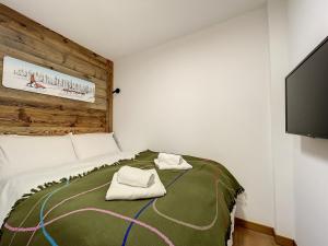 1 dormitorio con 1 cama con 2 toallas en Solaret - appartement- 4pers- Proche Centre, en Les Gets
