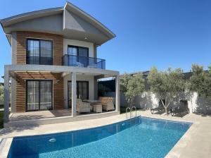 a house with a swimming pool in front of a house at Olive villas in Fethiye