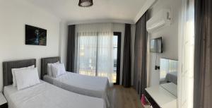 a hotel room with two beds and a window at Olive villas in Fethiye