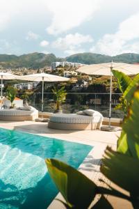 una piscina con sombrillas y vistas a la ciudad en The Views Baia - Adults Only en Funchal
