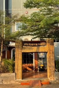 a building with a sign that reads you service house at You Empire Hostel & Bar in Pakse