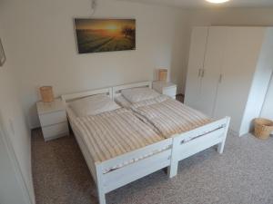 un letto bianco in una stanza con due comodini di Farmhouse in the M ritz National Park a Mirow