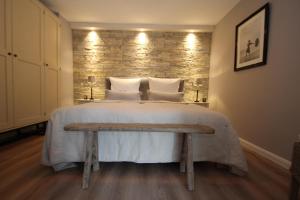 Un dormitorio con una cama grande y un banco. en Apartment Haus am Berg Lonau, en Lonau